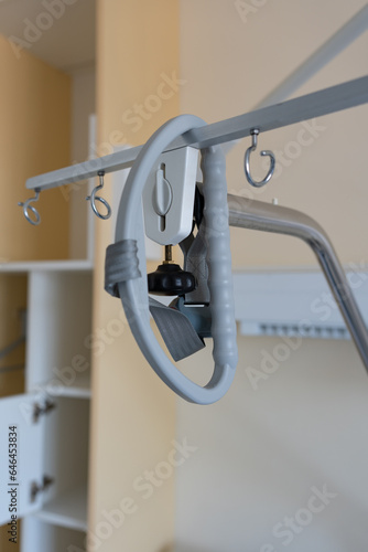 Gallow at the hospital bed in a hospital. Above hospital bed is hanging adaptive triangular metal frame.