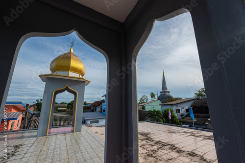 Dome of mosque and pagoda of temple in frame at Nakhon Si Thammarat, Thailand