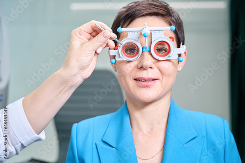Slika na platnu Vision specialist conducting monocular subjective refraction in female patient