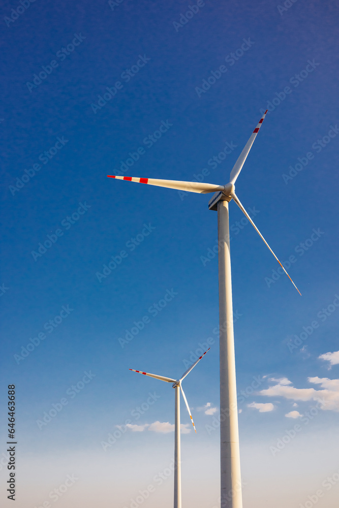 Windmill turbine with the blue sky on background