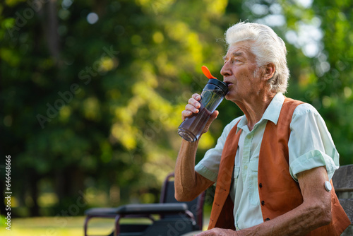 Senior man drinking water outdoor to better manage his diabetes. Elderly healthcare and diabetes in older people. 