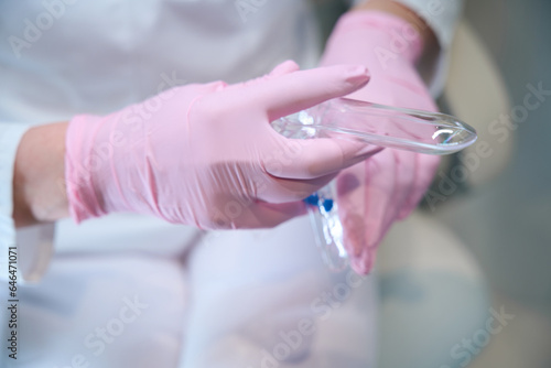 Woman gynecologist in protective gloves at the workplace