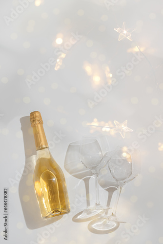 Top view sparkling wine and crystal wine glasses, bottle of champagne on shiny background, copy space. Festive alcoholic drink, party invitation, beautiful shadow and reflection, bokeh, aesthetic photo