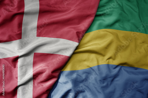 big waving national colorful flag of denmark and national flag of gabon .