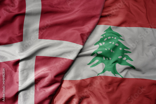 big waving national colorful flag of denmark and national flag of lebanon . photo