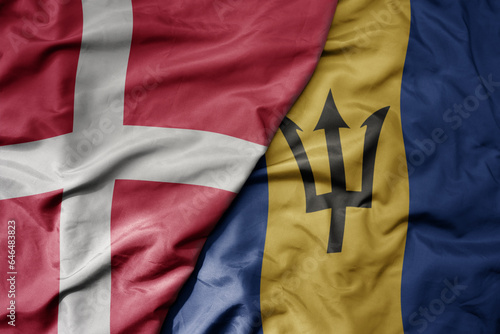 big waving national colorful flag of denmark and national flag of barbados .