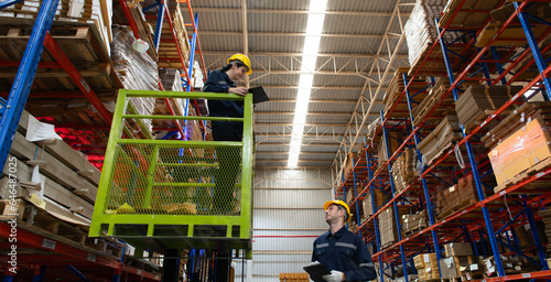 Warehouse workers using forklift to check and counting in a large warehouse. This is a large paper package storage and distribution warehouse.