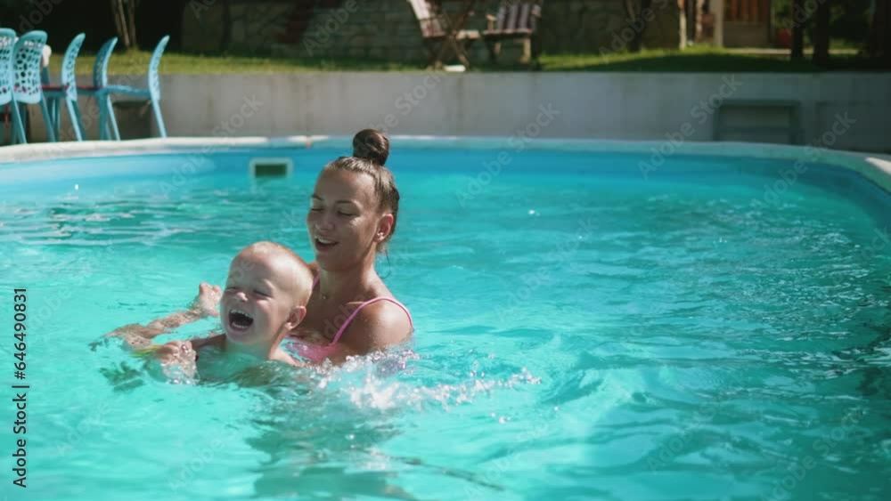 Happy little kid boy learning to swim with mom in the pool Happy little kid boy learning to swim with mom in the pool