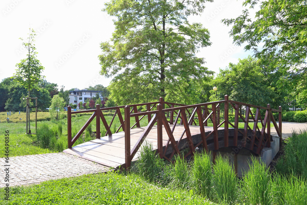 KRAKOW, POLAND - JUNE 23, 2023: Wooden bridge in the park on hot summer day.