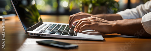 Wide banner of a man hands typing with a laptop and a mobile phone next to it wide web background banner 