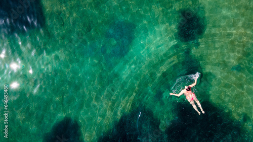 aerial view of a woman floating and reraxing in the sea