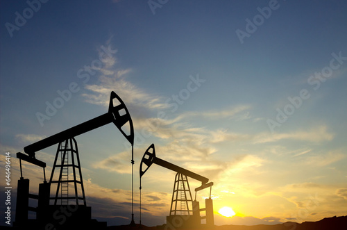 Silhouette of oil rigs against the sunset. Oil industry concept