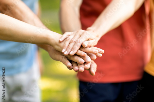 Unity Concept. Group Of Mature People Joining Hands Together While Standing Outdoors