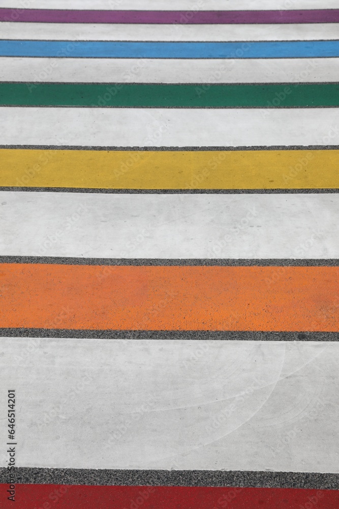 Fototapeta premium pedestrian crossing with the multicolored stripes of the road where pedestrians walk