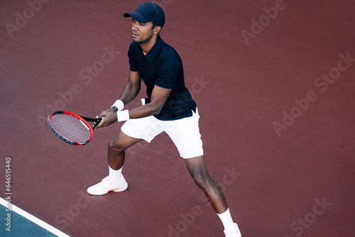 Fotografie Young tennis player standing on the tennis court baseline ready to return the se