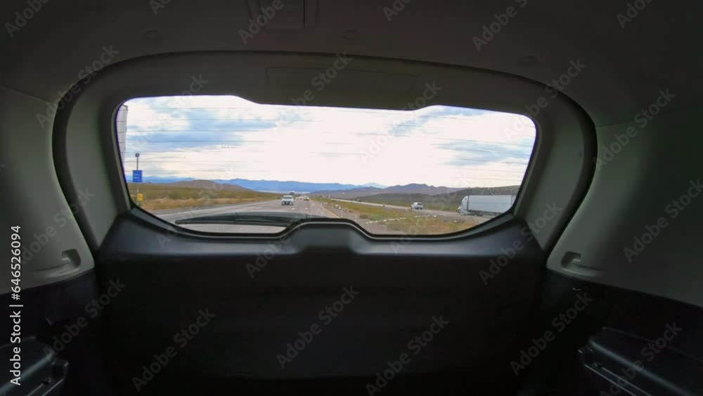 Back view from inside of the car to the road back and the traffic on the highway Back view from inside of the car to the road back and the traffic on the highway
