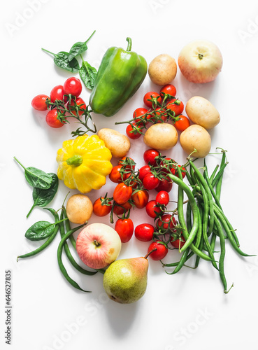 A variety of seasonal vegetables and fruits on a white background - cherry tomatoes  potatoes  string beans  squash  pear  apple