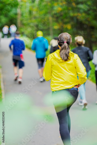 Blurred background of unrecognizable young runners at cross country race, sport concept
