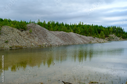 This is a former shale quarry with azure water and picturesque hills. Unlike the Narva shale settling ponds. A dark autumn day. Estonia, Aidu quarry. photo