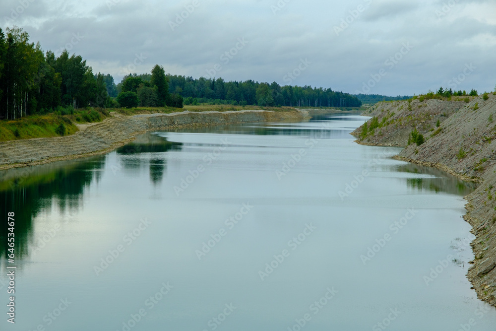 This is a former shale quarry with azure water and picturesque hills. Unlike the Narva shale settling ponds. A dark autumn day. Estonia, Aidu quarry.