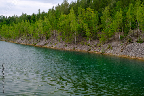 This is a former shale quarry with azure water and picturesque hills. Unlike the Narva shale settling ponds. A dark autumn day. Estonia, Aidu quarry. photo