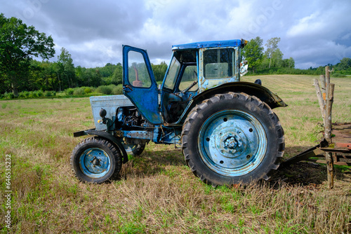Old blue Russian agricultural tractors in the field. Agricultural machinery in the farm. Special Agricultural Equipment. Durable agricultural machinery