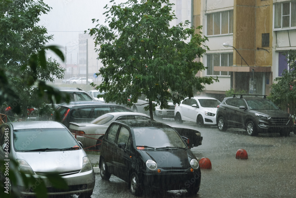 Fototapeta premium Cars parked in the yard under heavy rain
