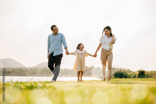 Happy family taking a walk together in the countryside on a beautiful sunny day, feeling healthy and active in the outdoors, Happy family day