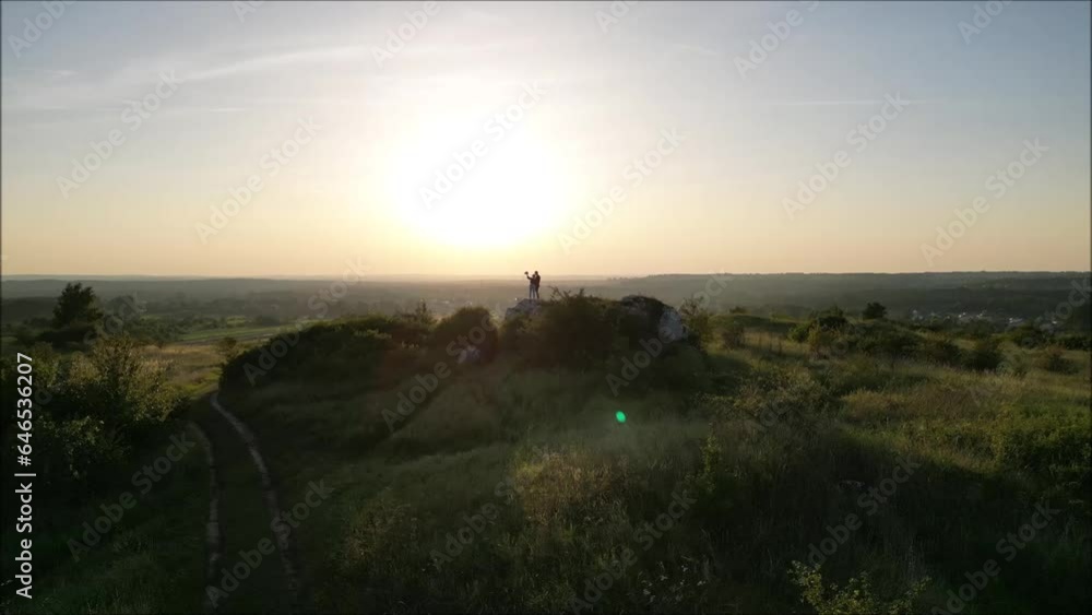 two people on the hill during sunset in the mountains two people on the hill during sunset in the mountains