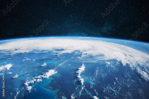 Amazing blue planet earth with ocean, clouds and continents in open space on the starry sky.