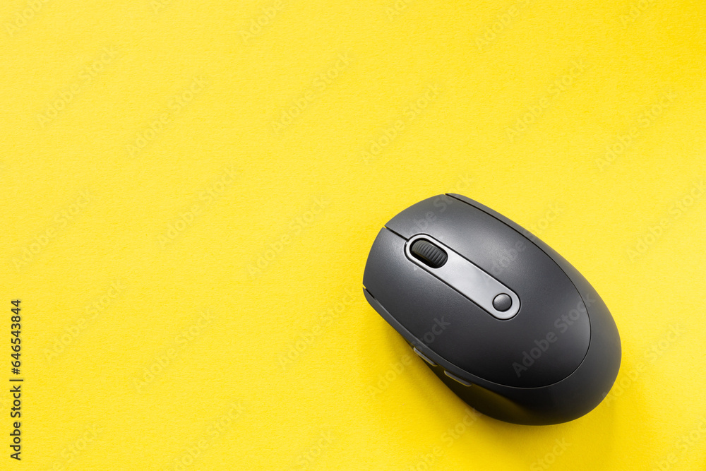 Black computer mouse on yellow background. Wireless optical PC mouse. Wireless technology Black computer mouse on yellow background. Wireless optical PC mouse. Wireless technology
