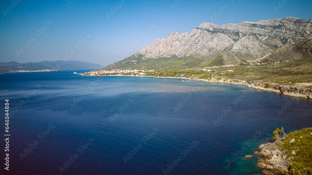 St. Elijah mountain rising high above town of Orebic on Peljesac peninsula, overlooking island of Korcula in the distance, photographed with drone