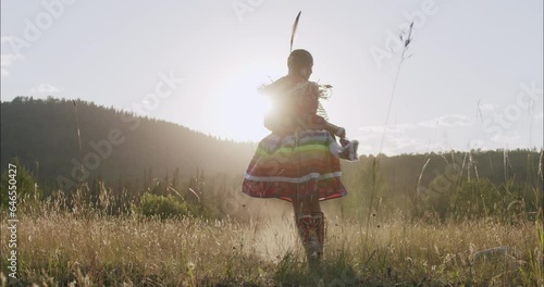 Beautiful Shot of Young Indigenous Woman Fancy Dancing In traditional Regalia photo
