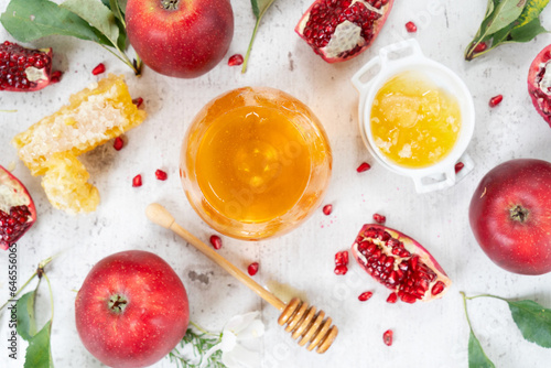 rosh hashana holiday - honey with apple and pomergranate over white desk background
