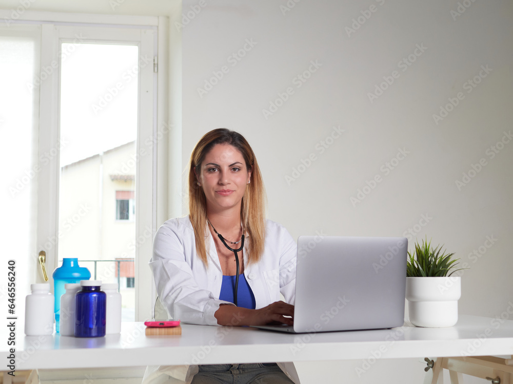 female doctor working on desktop with laptop computer female doctor working on desktop with laptop computer