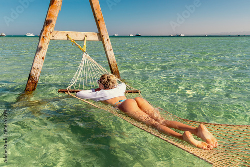 A beautiful girl lies in a hammock with her booty to the top