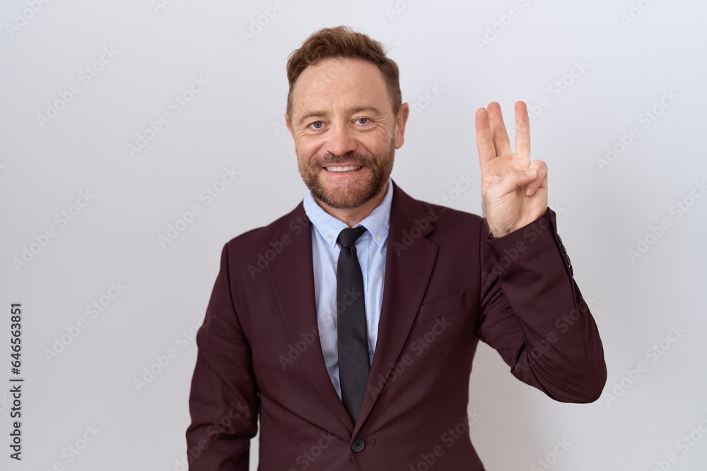 Middle age business man with beard wearing suit and tie showing and pointing up with fingers number three while smiling confident and happy. Middle age business man with beard wearing suit and tie showing and pointing up with fingers number three while smiling confident and happy.