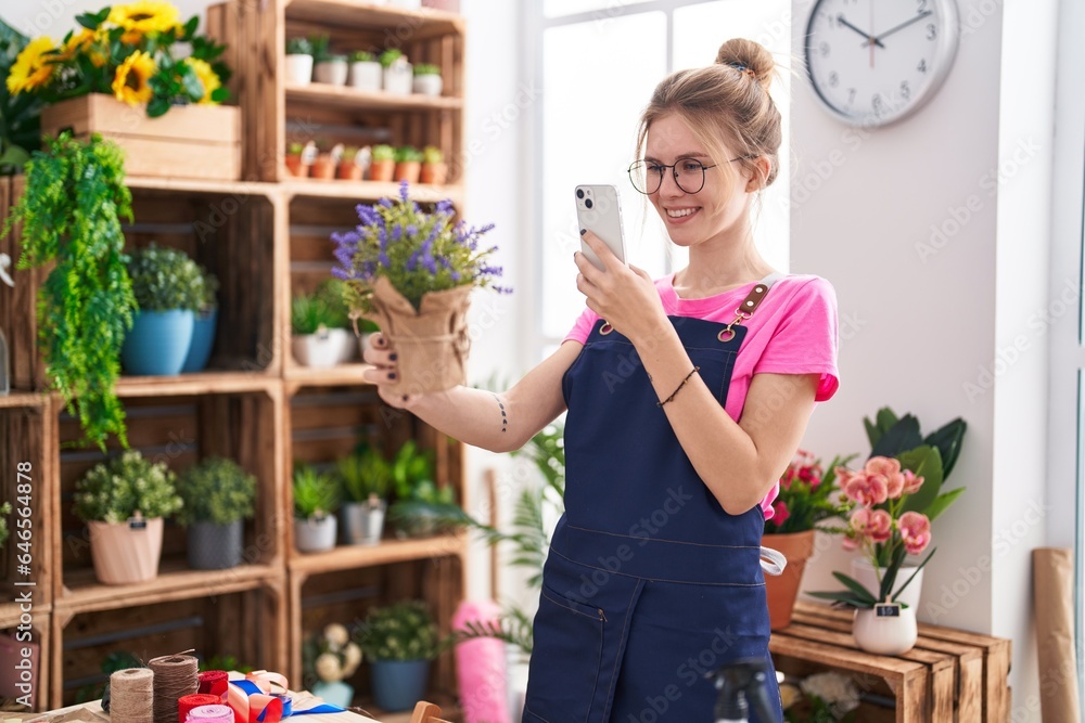 Young blonde woman florist make photo to lavender plant by smartphone at flower shop