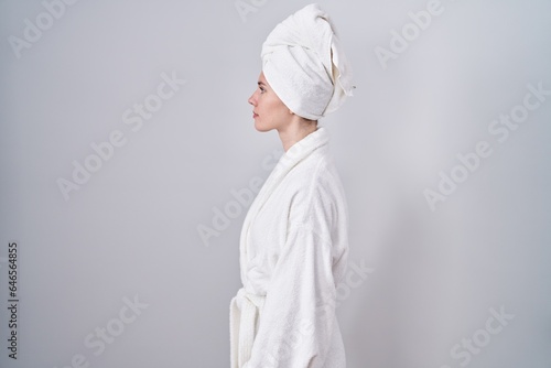 Blonde caucasian woman wearing bathrobe looking to side, relax profile pose with natural face and confident smile.