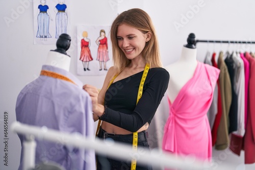 Young blonde woman tailor smiling confident measuring shirt at tailor shop