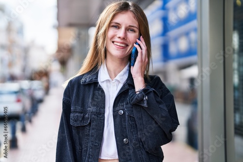 Young blonde woman smiling confident talking on the smartphone at street © Krakenimages.com
