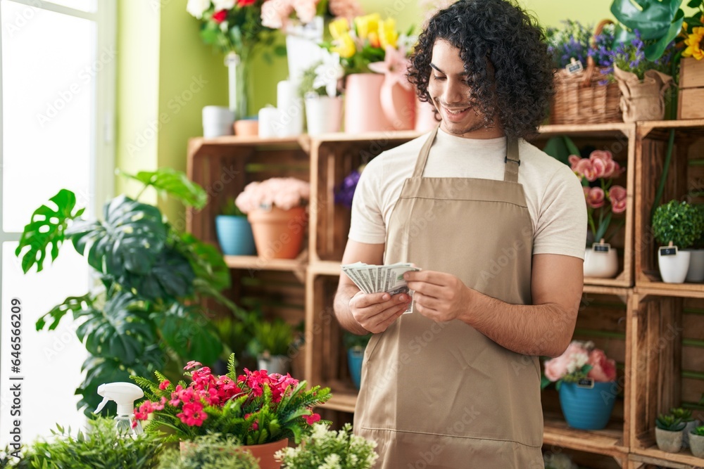 Young latin man florist smiling confident counting dollars at flower shop