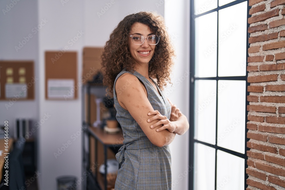 Fototapeta premium Young beautiful hispanic woman business worker smiling confident standing with arms crossed gesture at office