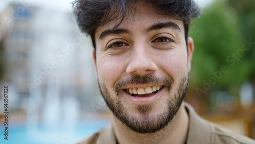 Young hispanic man smiling confident standing at park