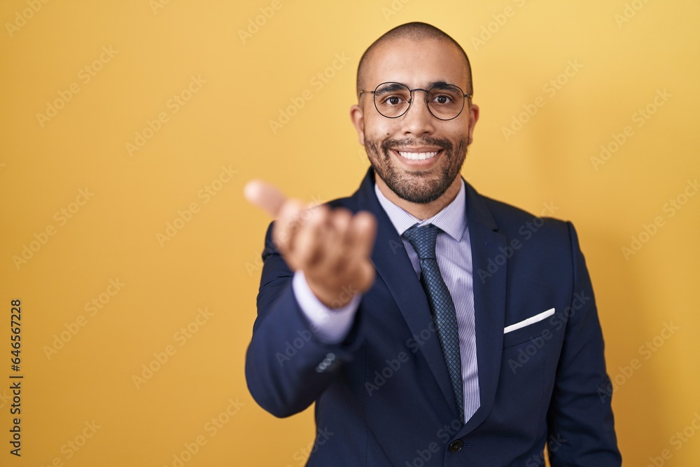 Hispanic man with beard wearing suit and tie smiling friendly offering handshake as greeting and welcoming. successful business. Hispanic man with beard wearing suit and tie smiling friendly offering handshake as greeting and welcoming. successful business.