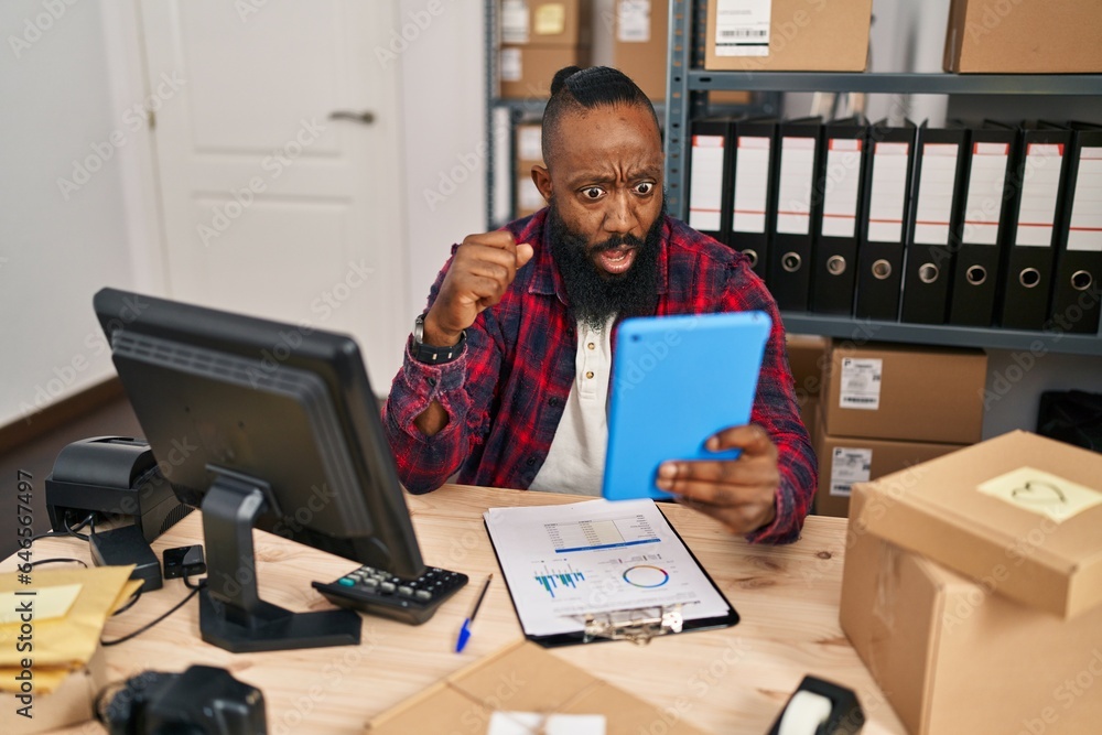 African american man working at small business ecommerce doing video call scared and amazed with open mouth for surprise, disbelief face African american man working at small business ecommerce doing video call scared and amazed with open mouth for surprise, disbelief face