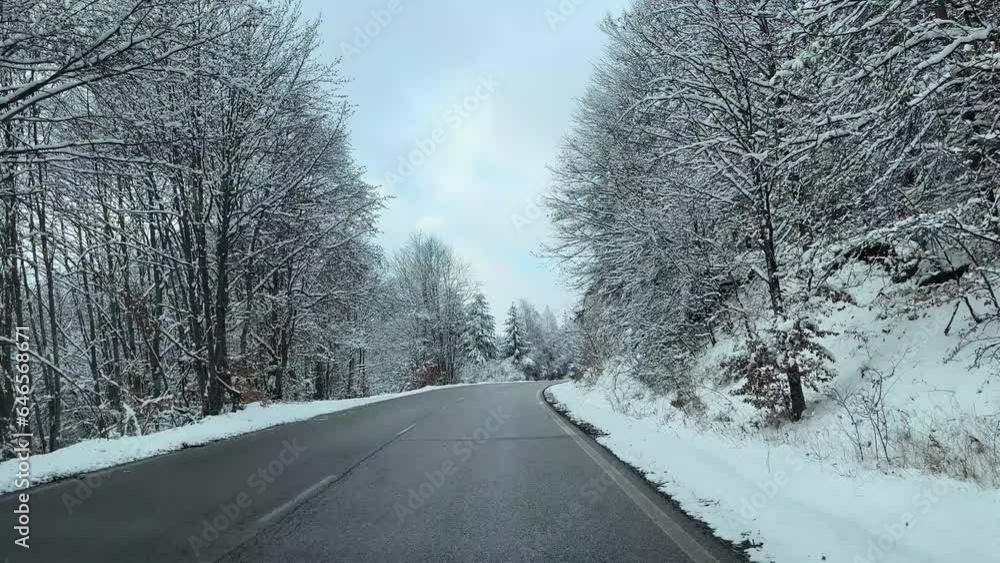 View through the windshield on the highway in winter along which the car is driving in heavy snow and wind View through the windshield on the highway in winter along which the car is driving in heavy snow and wind