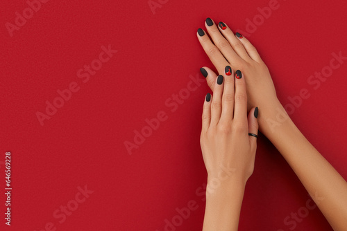 Manicured female hands with fashion accessories. Trendy autumn halloween bloody spooky nail design.