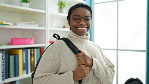 African american woman student smiling confident wearing backpack at library university