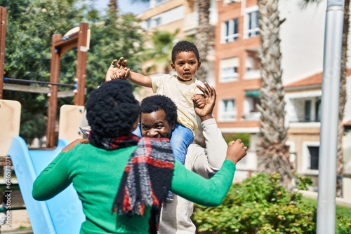 African american family holding boy on shoulders at playground © Krakenimages.com